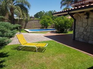una silla amarilla sentada en el césped junto a una piscina en La Deolinda en Funes