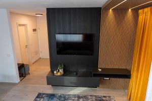 Apart B&V في براشوف: غرفة معيشة مع جدار أسود مع تلفزيون بشاشة مسطحة
