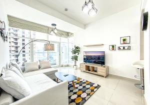een woonkamer met een bank en een tv bij Walk To The Beach Or Enjoy The Amazing View From The Balcony in Dubai