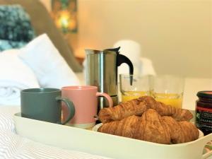 a tray of croissants and coffee and cups on a bed at Restful 1-Bedroom flat in St Helens in Saint Helens +23 photos