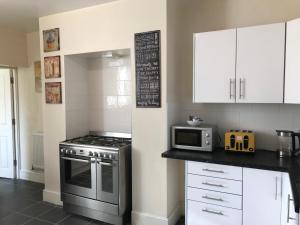a kitchen with a stove and a microwave at Welcoming spacious 2-bedroom house in St Helens in Saint Helens