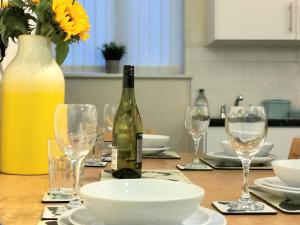 a table with a bottle of wine and glasses at Welcoming spacious 2-bedroom house in St Helens in Saint Helens