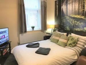 ein Schlafzimmer mit einem Bett mit zwei Handtüchern darauf in der Unterkunft Welcoming spacious 2-bedroom house in St Helens in Saint Helens