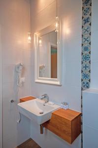 La salle de bains est pourvue d'un lavabo et d'un miroir. dans l'établissement Monaco Ville, à Międzyzdroje
