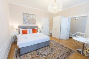 - une chambre avec un grand lit blanc et un lustre dans l'établissement Parkview Boutique Apartments, à Vienne