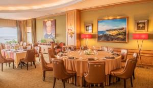 a conference room with tables and chairs and a painting at Hotel Cascais Miragem Health & Spa in Cascais