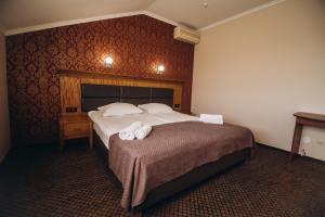 a hotel room with a bed with towels on it at Zlagoda in Ternopilʼ