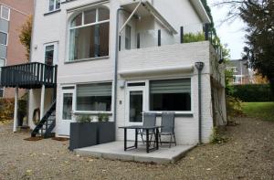 een huis met een tafel en stoelen ervoor bij Appartement Dersaborg in Valkenburg