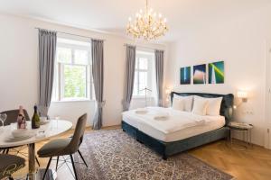 1 dormitorio con 1 cama, mesa y sillas en Parkview Boutique Apartments, en Viena