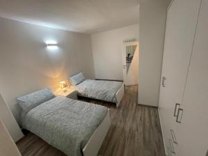 a small room with two beds and a cabinet at Casa Vacanza Revolta in Trento