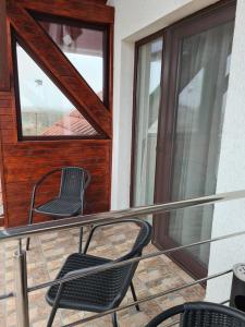 a pair of chairs sitting on a balcony at Pensiunea Maya in Cenad