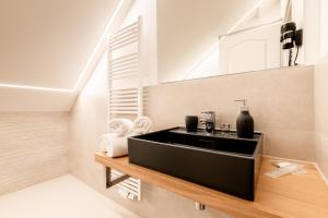 a bathroom with a black sink and a staircase at Hotel auszeit Neunkirchen-Seelscheid in Neunkirchen