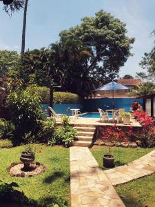 a backyard with a swimming pool and a house at Pousada Canto Bella Terra in Ilhabela