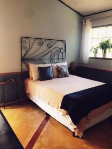 - une chambre avec un grand lit et une fenêtre dans l'établissement Pousada Canto Bella Terra, à Ilhabela