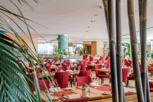 a dining room with red chairs and tables at Hotel Cascais Miragem Health & Spa in Cascais