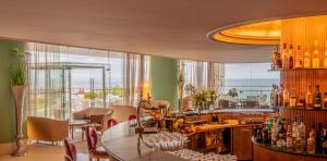 a restaurant with a bar with a view at Hotel Cascais Miragem Health & Spa in Cascais