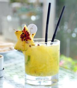 a drink with pineapple and black straws on a table at Hotel Cascais Miragem Health & Spa in Cascais
