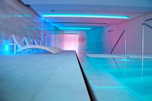a room with a pool with chairs and a table at Hotel Cascais Miragem Health & Spa in Cascais
