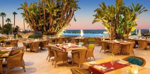 a restaurant with tables and chairs with the ocean in the background at Hotel Cascais Miragem Health & Spa in Cascais