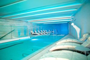 a large swimming pool with pillows and beds in it at Hotel Cascais Miragem Health & Spa in Cascais