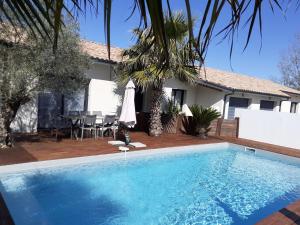 - une piscine en face d'une maison dans l'établissement ViLLA NEUVE 115m2 ,TOUT CONFORT AVEC PiSCiNE Chauffée-JARDiNET BASSiN ARCACHON, à Gujan-Mestras