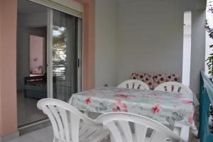 a dining room with a table and two white chairs at Niki Apartments in Polychrono