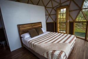 una camera con un grande letto in una tenda di Reserva del Dorado a Sesquilé