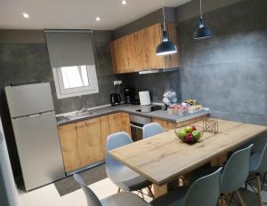 a kitchen with a wooden table and some chairs at VIRGIN ROCKS APARTMENTS 1 in Kalabaka