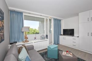 ein Wohnzimmer mit einem Sofa und einem großen Fenster in der Unterkunft Ferienwohnung Eydum Nr 10 in Westerland