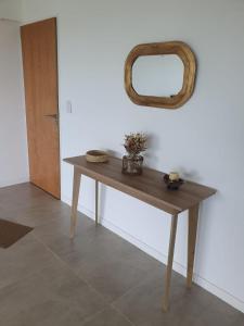 a wooden table with a mirror on the wall at Departamento a estrenar con vista al río in Victoria
