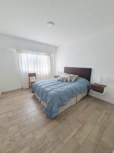 a bedroom with a bed and a wooden floor at Departamento con vista al río in Victoria