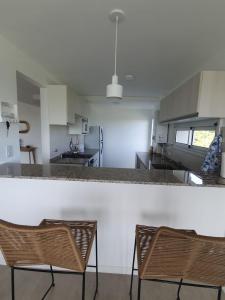 a kitchen with two chairs and a counter top at Departamento a estrenar con vista al río in Victoria