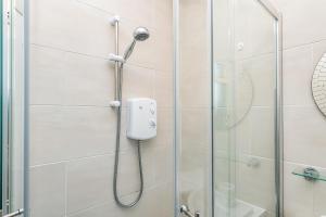 a shower with a shower head in a bathroom at Balmoral Residence 30 mins from Edinburgh and Glasgow in Falkirk +19 photos