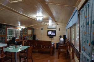 a man sitting at a table in a restaurant at Ji Ji Farm Homestay in Jiji