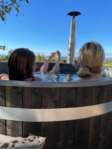 Zwei Frauen sitzen in einem Whirlpool in der Unterkunft Det Gamla Panget in Tällberg