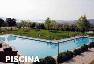 ein großes Schwimmbecken mit einem Park im Hintergrund in der Unterkunft Mendia in Jaca