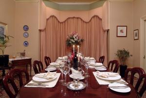 a dining room with a long table with chairs at The Lodge Country House in Marananga