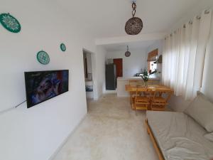 a living room with a couch and a table at Vila Pitangueira - Apto Verde - No Centro de Serra Grande com Piscina, Jacuzzi, Internet Rápida in Serra Grande