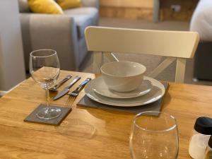 a table with a plate and two glasses on it at Studio at Bastion Mews in Hereford