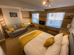 1 dormitorio con 1 cama grande y 1 sofá en Studio at Bastion Mews en Hereford