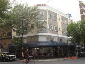 a man riding a bike in front of a building at Suite Confortable en Palermo Omega in Buenos Aires