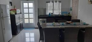 uma cozinha com uma mesa com cadeiras e um frigorífico em Blue Sky Villa em Grand Baie