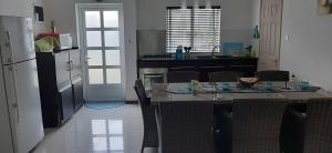 a kitchen with a table with chairs and a refrigerator at Blue Sky Villa in Grand-Baie