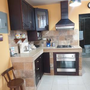 una cucina con armadi marroni e piano cottura. di Blanca Apartments a Guayaquil
