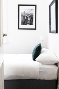 a white bed with a green pillow in a room at Wynyard Hotel in Sydney