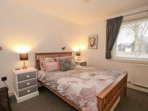 ein Schlafzimmer mit einem großen Bett und einem Fenster in der Unterkunft Sunset Lodge in Tattershall