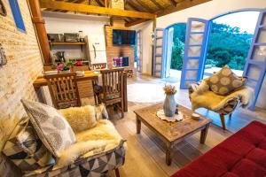 a living room with a couch and chairs and a table at Chalé do Lago super Luxo in Cunha