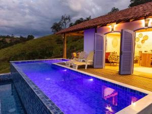 a house with a swimming pool and a deck at Chalé do Lago super Luxo in Cunha