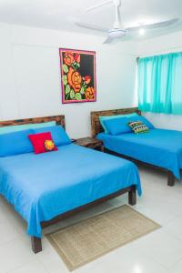 2 camas en una habitación con sábanas azules en Hotel Henry Bacalar en Bacalar