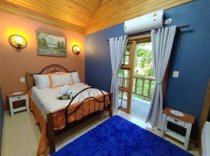 um quarto com uma cama e uma grande janela em Cabana Drechsler Gramado em Gramado